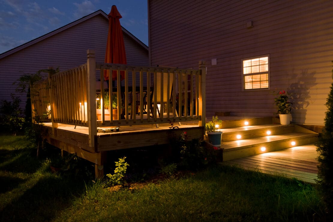 Wooden deck and patio with outdoor lighting at night
